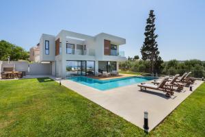 a large villa with a swimming pool and lawn at pirgos-villas, Avra & Ostria villa, Heated pool , amazing sea view in Maleme