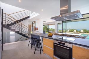 a kitchen with a counter with a sink and a staircase at pirgos-villas, Avra & Ostria villa, Heated pool , amazing sea view in Maleme