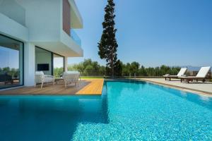 a swimming pool next to a house at pirgos-villas, Avra & Ostria villa, Heated pool , amazing sea view in Maleme