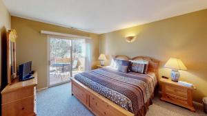 a bedroom with a bed and a television and a patio at Kokopelli's Kiva #3230 in Moab