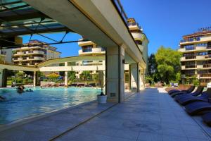 a swimming pool next to a building with buildings at Infinity View Shkorpilovci in Shkorpilovtsi