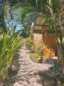 ein Steinweg vor einem Haus mit einer Bank in der Unterkunft Gili Matiki, Resort & Private Villa in Gili Air