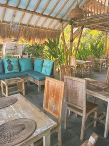 eine Terrasse mit einem blauen Sofa sowie Tischen und Stühlen in der Unterkunft Gili Matiki, Resort & Private Villa in Gili Air + 141 Fotos