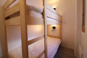 a bunk bed in a small room with a ladder at Residence Pralin in Méribel