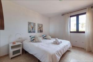 een witte slaapkamer met een bed en een raam bij Fuerteventura Apartamento Costa Calma, Jandia in Costa Calma