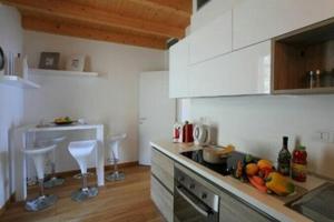 eine Küche mit weißen Schränken und einer Arbeitsplatte in der Unterkunft PARADISO DEL LAGO MARGHERITA 1 in Bellano