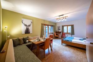 a living room with a couch and a table and a bed at Sport-Lodge Klosters in Klosters