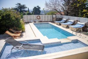 una piscina con tumbonas y una piscina en Casa Alta Hotel Boutique & Spa - Solo Adultos en Villa Carlos Paz