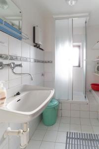 y baño blanco con lavabo y ducha. en chalupa U Hovorků a chatky - u pískoven Vlkov, en Veselí nad Lužnicí