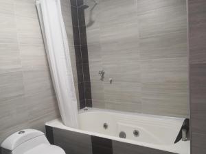 een badkamer met een bad en een toilet bij Miski Wasi Hospedaje Neiva in Neiva