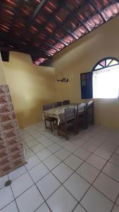 ein Esszimmer mit einem Tisch, Stühlen und einem Fenster in der Unterkunft Casa de praia em ponta de areia - Raio do Sol House in Itaparica Town