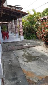a patio with a red bench and a house at Casa de praia em ponta de areia - Raio do Sol House in Itaparica