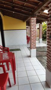 a patio with a red table and chairs and a building at Casa de praia em ponta de areia - Raio do Sol House in Itaparica