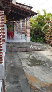 a house with a red table on a patio at Casa de praia em ponta de areia - Raio do Sol House in Itaparica