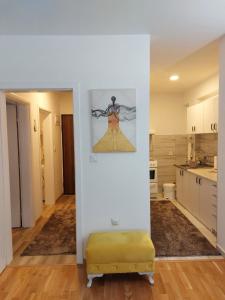 une chambre avec un mur blanc et un pouf jaune dans une cuisine dans l'établissement Apartment YESA, à Travnik
