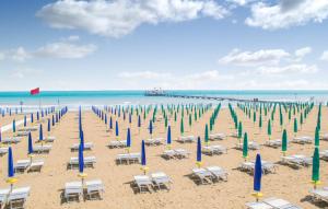 una playa con sillas y sombrillas y el océano en SOLARE, en Bibione