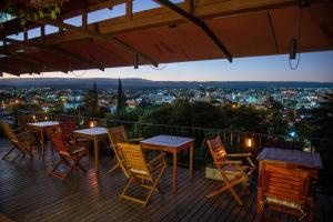 een terras met tafels en stoelen en uitzicht op de stad bij Casa Alta Hotel Boutique & Spa - Solo Adultos in Villa Carlos Paz