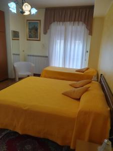 2 letti in camera d'albergo con lenzuola gialle di Hotel Ristorante Supersonik ad Acri