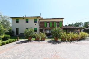 ein Haus mit Topfpflanzen davor in der Unterkunft Agriturismo Corte Stefani in Capannori