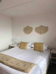 - une chambre avec un lit blanc et 2 oreillers dans l'établissement Sweet & Simple Beach Cottage, à Jeffreys Bay