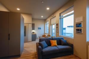 - un salon avec un canapé bleu et une fenêtre dans l'établissement Center Apartments - Esja, à Reykjavik