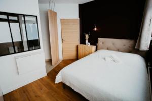 een slaapkamer met een wit bed en een raam bij Sweet Love Room - Jacuzzi Privatif in Montreuil