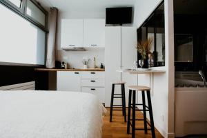 a bedroom with a bed and a kitchen with stools at Sweet Love Room - Jacuzzi Privatif in Montreuil