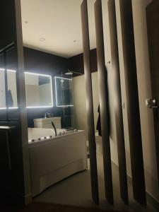 un baño con lavabo y bañera en Sweet Love Room - Jacuzzi Privatif, en Montreuil