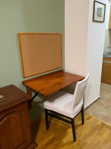 a wooden table with a white chair and a desk at apartment24 in Skopje