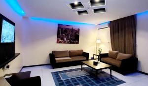 sala de estar con sofá y TV en Address Sharurah Hotel en Sharurah