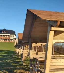 a row of wooden picnic tables in front of a house at Maramures BELVEDERE in Petrova