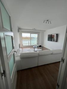 a living room with a white couch and a window at Apartamento cerca centro Madrid in Rivas-Vaciamadrid