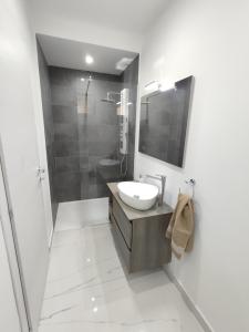 a white bathroom with a sink and a shower at Il-Girna in Marsaskala