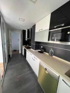 uma cozinha com armários a preto e branco e uma bancada em Apartamento cerca centro Madrid em Rivas-Vaciamadrid