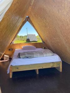 Bett in einem Zelt mit Fenster in der Unterkunft Villa Pancha del Lunarejo in Sierra de Lunarejo