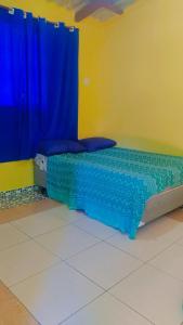 uma cama num quarto com azul e amarelo em Paraty casa suite em Paraty