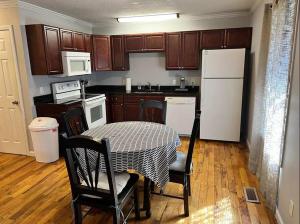a kitchen with a table and a white refrigerator at Cozy 2 Bedroom Townhouse Near Lake and Restaurants in Guntersville