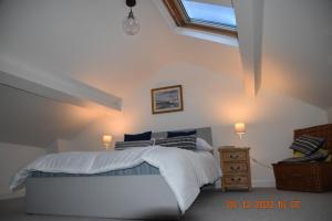 a bedroom with a bed with white sheets and pillows at Ty Alban in Ffestiniog