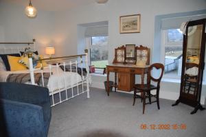 a bedroom with a bed and a desk with a bed and a desk at Ty Alban in Ffestiniog