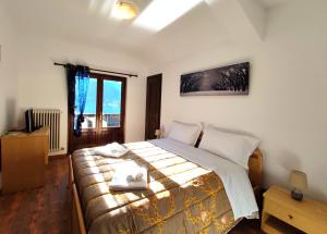 1 dormitorio con 1 cama con 2 toallas en Hotel TEA Dolomiti en Alleghe