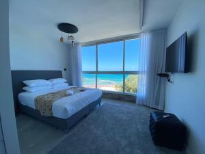 een slaapkamer met een bed en uitzicht op de oceaan bij sea view apartment in Bat Yam