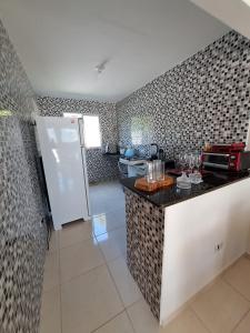a kitchen with a counter and a refrigerator in it at Maria Farinha casa in Maria Farinha