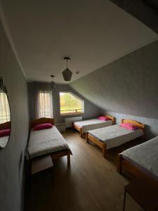 a room with three beds and a window at Brīvdienu māja “Dzirnavnieki” in Bauska