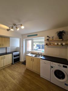 een keuken met een wastafel en een wasmachine bij The North Bay Hideaway, Scarborough in Scarborough