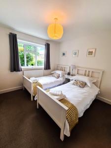 a bedroom with two beds and a window at The North Bay Hideaway, Scarborough in Scarborough