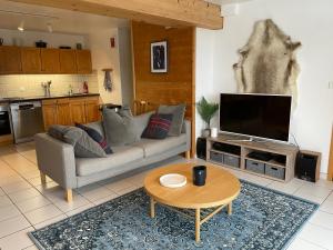 uma sala de estar com um sofá e uma televisão em Central Morzine, Spacious 2 Bedroom Family Apartment em Morzine