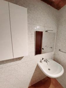 Baño blanco con lavabo y espejo en Trastevere in Music, en Roma