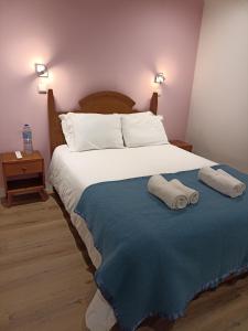 ein Schlafzimmer mit einem Bett mit zwei Handtüchern darauf in der Unterkunft Martim Moniz 28 Guest House in Lissabon