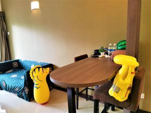 a dining room with a wooden table and a couch at FREE 4 WATER THEMEPARK Tickets & WiFi Stay Melaka in Melaka