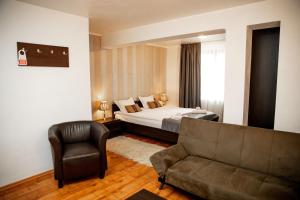 a hotel room with a bed and a couch at Velinov Boutique Hotel in Bansko